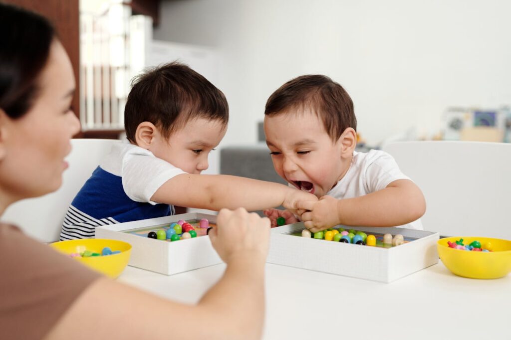 Two young boys playfully interacting with wooden beads at home.